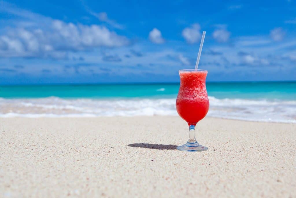 Wie gefährlich ist Alkohol Cocktail am Strand mit Meer im Hintergrund