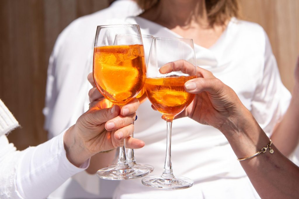 Wie schädlich ist Alkohol ; Männer und Frauen mit Weingläsern