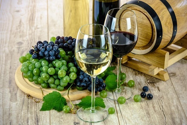 Alkohol und Vitaminmangel 2 Weingläser, Trauben und ein Faß